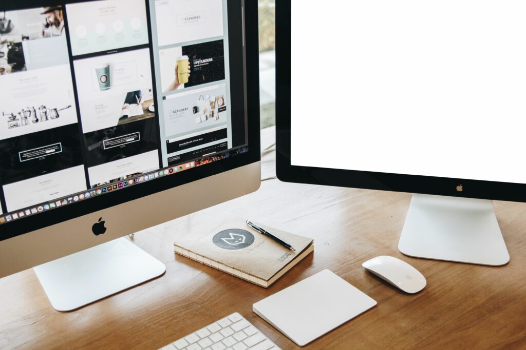 Ordinateur affichant des maquettes de sites web sur un bureau